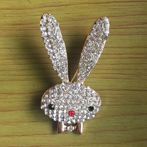 Macro shot of a golden rabbit brooch with sparkling rhinestones and red nose detail
