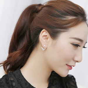 Close-up of rose gold petal earrings with white marquise zircons on a model's ear