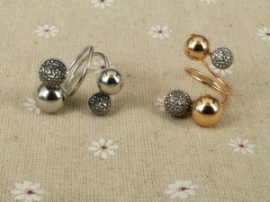 Detailed macro view of spiral gold and silver rings featuring polished and rhinestone beads