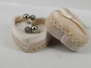 Detail of bypass ring with polished and pavé beads in heart-shaped velvet box