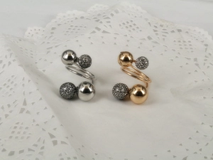 Detail view of spiral open rings with polished and frosted beads in silver and gold finish