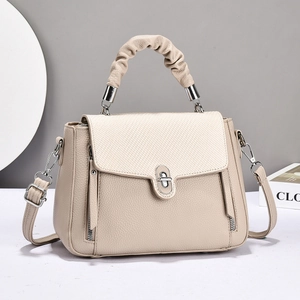 Fashionable beige crossbody handbag with textured leather finish and top handle