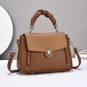 Brown lychee leather handbag with woven flap and decorative cloud-shaped handle