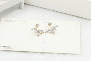 Detail shot of silver stud earrings with marquise cubic zirconia on soft white fur