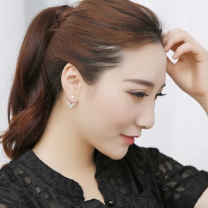 Macro detail of zircon daisy flower stud earrings with marquise stones on model's ear