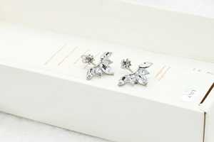 Macro shot of silver stud earrings featuring marquise-shaped zircons in a leaf design