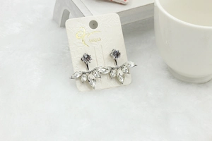 Macro detail of silver marquise cubic zirconia daisy flower earrings on cardholder
