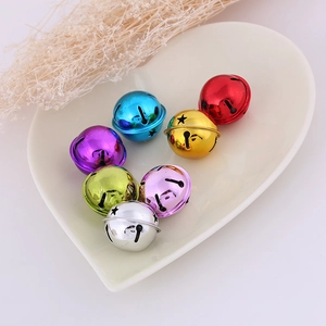 Close-up of colorful star cutout metal bells in a decorative white heart ceramic plate