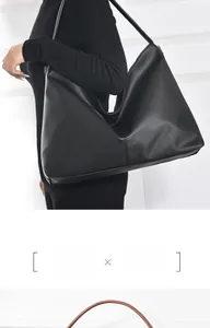 Detailed close-up of premium black lychee grain leather on a hobo shoulder bag