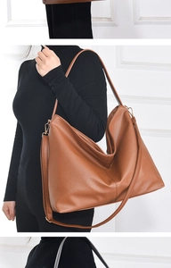 Detail showing the brown lychee pattern texture and metal buckle on the crossbody bag