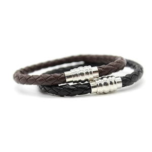 Close-up of black and brown braided leather bracelets with silver magnetic clasps