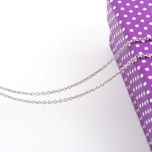 Detailed view of 316L stainless steel silver chain necklace next to purple gift box