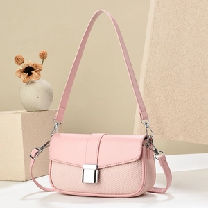 Detail of pink crossbody bag showing woven texture and silver buckle on stone stand