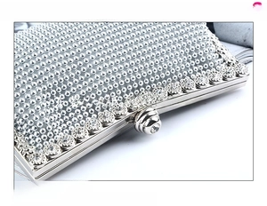 Detail shot of elegant silver evening clutch featuring sparkling rhinestones and a crystal clasp