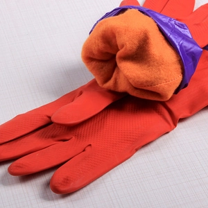 Detail of red rubber cleaning gloves showing orange thermal fleece lining and purple cuff