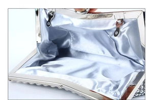 Detail view of silver evening clutch bag featuring smooth satin lining and metal closure