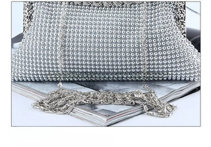 Close-up of a silver beaded evening clutch featuring a metallic mesh and elegant chain