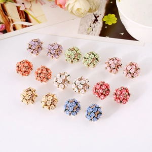 Macro detail of assorted enamel flower stud earrings with sparkling crystal accents
