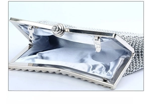 Detail of silver evening clutch with rhinestone lock and light blue satin interior lining