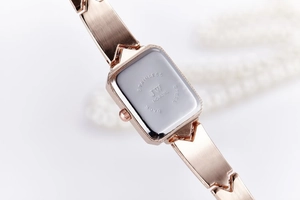 Macro shot of stainless steel back and geometric bracelet on a rose gold women's watch