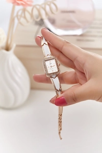 Close-up of women's rose gold square watch with crystal bezel and ceramic strap