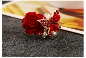 Detailed close-up of bohemian rose ring with red rhinestones and gold butterfly