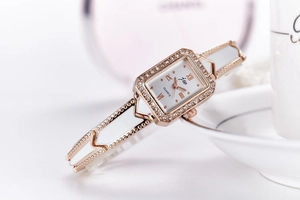 Macro shot of rectangular quartz watch with rhinestone bezel and rose gold hollow chain band