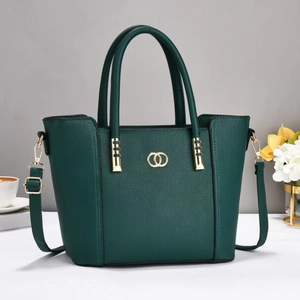 Deep green textured tote bag with golden hardware and adjustable strap in studio setting