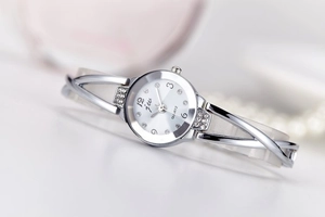 Detailed macro shot of silver quartz watch with white rhinestone dial and metal strap