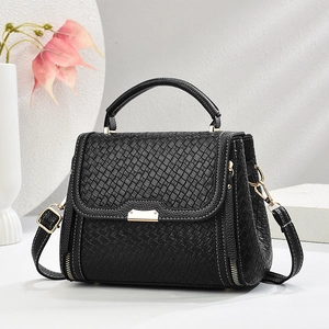 Minimalist black woven leather crossbody bag with top handle and gold zipper hardware