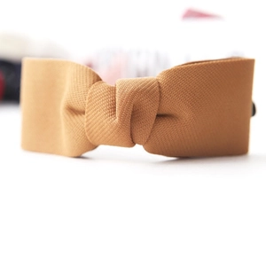 Elegant mustard yellow bow hair clip with fabric texture for stylish ponytail styling