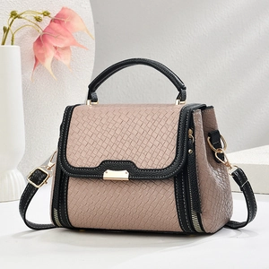 Elegant dusty pink woven tote bag with black leather handles and gold metal hardware