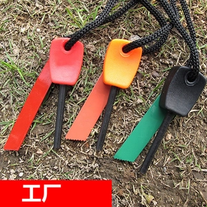Outdoor flint fire starter set with red orange and green handles on natural grass