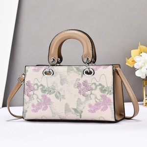 Détails de broderie florale rétro et poignées en cuir kaki sur ce sac cabas élégant