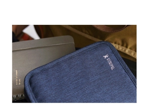 Detailopname van blauwe stoffen reishouder met SITUYU-logo op een bureau met decor
