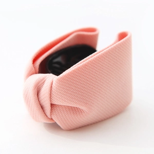 Detailed close-up of pink textured fabric hair claw clip on a white background