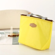 Macro shot of yellow insulated oxford lunch bag with gray handles and zipper detail