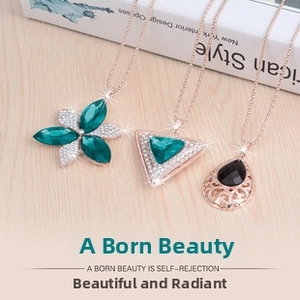 Detailed view of rose gold pendants with green crystals on a warm wood surface