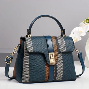 Navy blue crossbody bag with orange stripes and gold lock on minimalist background