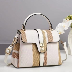 Chic two-tone canvas tote bag with white base and brown stripes in elegant indoor setting