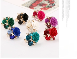 Macro shot of resin rose rings with crystals in eight vibrant colors on golden bands