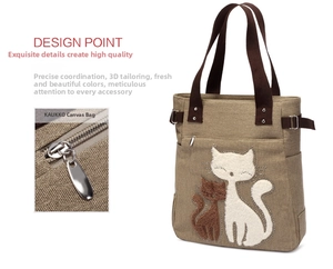 Detail of khaki canvas tote featuring cat embroidery and high-quality metal hardware