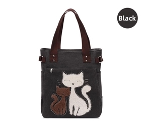 Close-up of cat embroidery with metal studs on a dark grey canvas handbag with straps