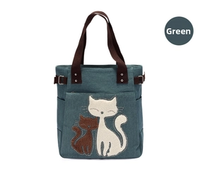 Detail of green canvas cat tote bag featuring front pocket and side metal buckle