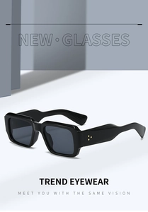 Detailed view of black square sunglasses with three gold floral rivets on the temples