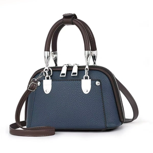 Navy blue pebble leather boston handbag with dark brown handles and detachable strap