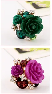 Detailed macro view of vintage resin rose rings with crystal accents in green and purple