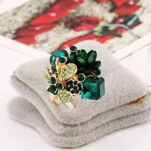 Exquisite gold floral ring featuring dark green crystal center and emerald gemstones