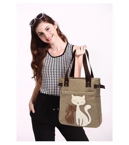 Detail view of canvas tote bag featuring cute cat embroidery and rhinestone accents