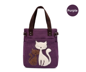 Detail of purple canvas tote bag with cute cat embroidery and brown woven handle